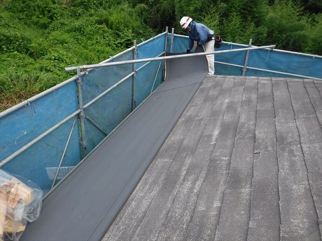 防水シートを屋根の下の方から貼っていく